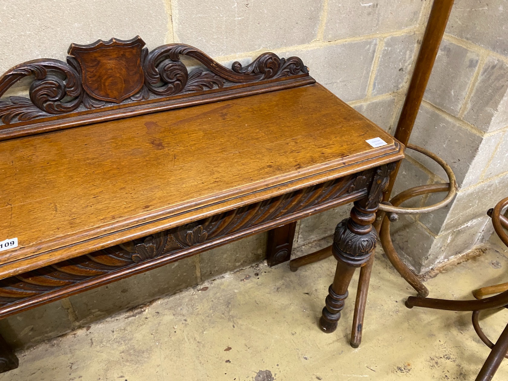 A Victorian oak console table, vacant shield cartouche and scrolling acanthus surmount to back, width 120cm, depth 42cm, height 102cm